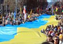 la gente camina con una bandera ucraniana gigante de muchos metros de largo para protestar contra la invasion rusa de ucrania durante una celebracion de la independencia de lituania
